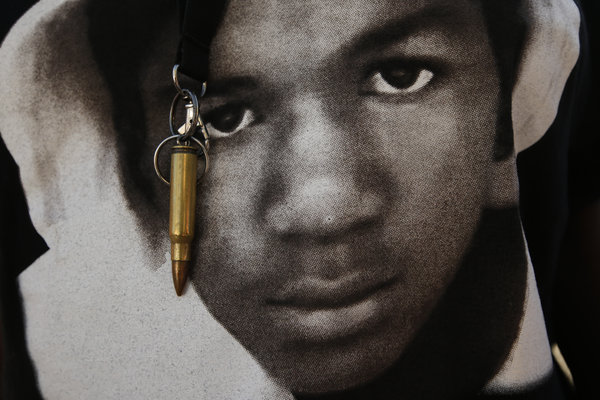 An image of Trayvon Martin and a bullet shell keychain hanging from a protester's lanyard are seen during a demonstration in reaction to the acquittal of neighborhood watch volunteer George Zimmerman on Monday, July 15, 2013, in Los Angeles.   (AP Photo/Jae C. Hong)