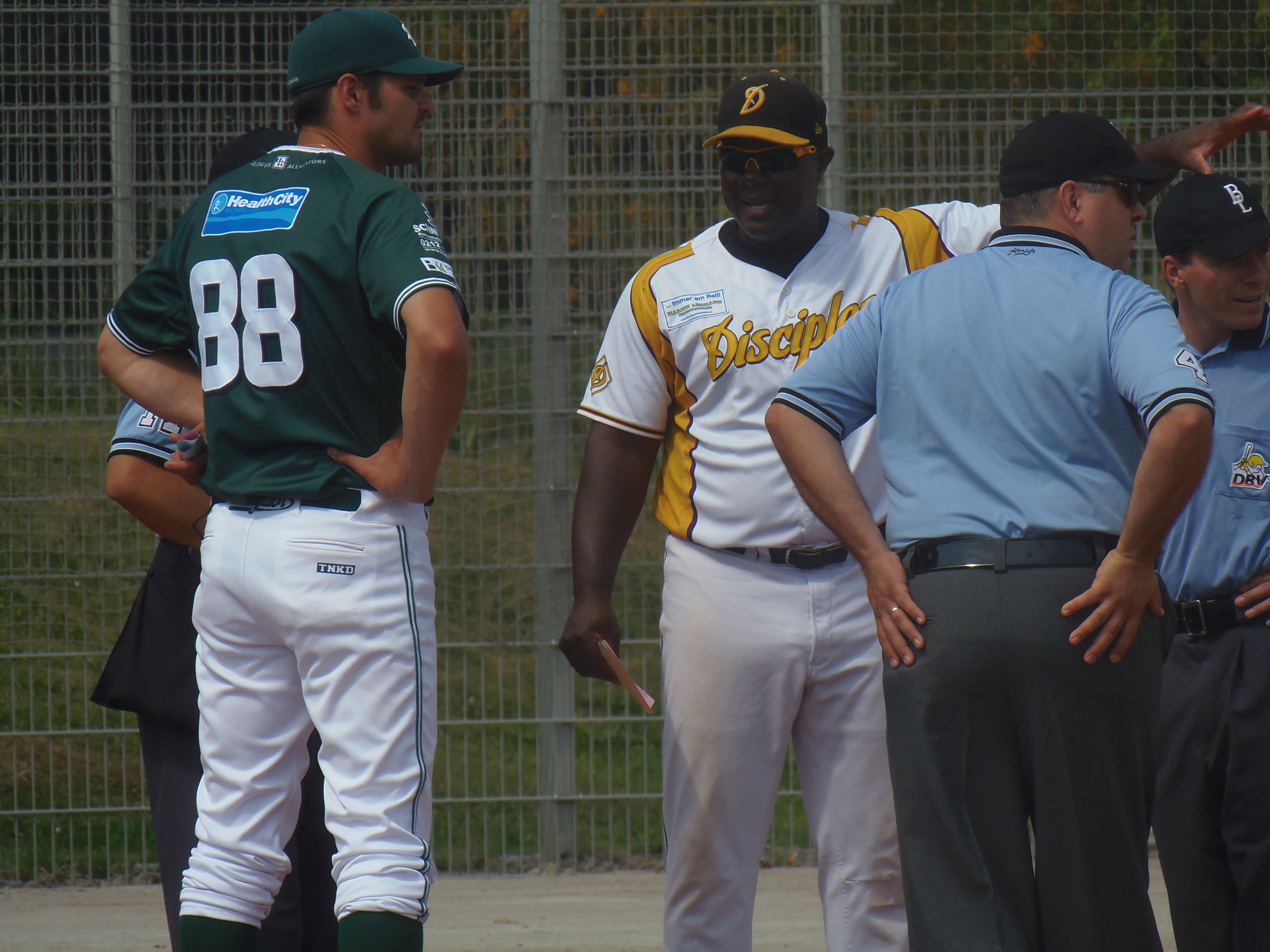 Solingen Alligators coach Norman Eberhardt (Nr. 88) confers with umpires and Haar Dicsiples head coach Keith Maxwell to exchange line-up cards and discuss ground rules before the two teams' playoff action.
Photo: Douglas Sutton