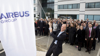 Tom Enders, CEO of Airbus Group, raising a flag with a new logo in front of Airbus Group Headquarters in Toulouse, France. -- photo: dpa