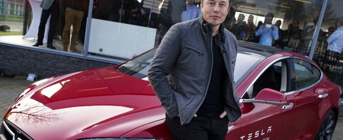 Elon Musk, co-founder and CEO of Tesla, poses with a model of his own car brand on 31 January 2014. Photo: dpa