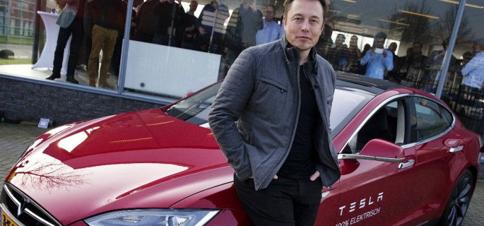 Elon Musk, co-founder and CEO of Tesla, poses with a model of his own car brand on 31 January 2014. Photo: dpa